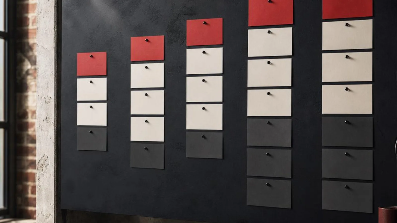 Sales pipeline arranged with red, ivory, and charcoal cards on a planning wall